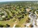 Expansive aerial view showcasing the golf course and the surrounding residential area, with mature trees and landscaping at 1489 Dundee Dr, Palm Harbor, FL 34684