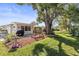 Lovely backyard featuring a swing under a large tree, patio, and a well-maintained lawn at 1489 Dundee Dr, Palm Harbor, FL 34684