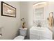 Clean and bright half bathroom featuring modern fixtures and marble accents at 1489 Dundee Dr, Palm Harbor, FL 34684