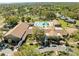 Aerial view of a clubhouse with a swimming pool and well-maintained landscaping in a lush, green setting at 1489 Dundee Dr, Palm Harbor, FL 34684