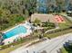 Aerial view of the community pool area featuring a playground and lounging chairs at 1489 Dundee Dr, Palm Harbor, FL 34684