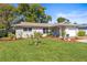 Charming single-story home with a well-manicured lawn and beautiful landscaping at 1489 Dundee Dr, Palm Harbor, FL 34684