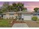 Charming home at dusk showcasing manicured landscaping adding to its curb appeal at 1489 Dundee Dr, Palm Harbor, FL 34684