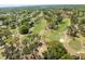 The aerial view highlights a golf course with lush fairways and residential surroundings at 1489 Dundee Dr, Palm Harbor, FL 34684