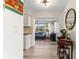 Hallway view into a living room with tiled floor, blue sofa, piano, windows, and ceiling fan at 1489 Dundee Dr, Palm Harbor, FL 34684
