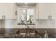 Close-up of a stainless steel kitchen sink with modern faucet and a view to the outdoors at 1489 Dundee Dr, Palm Harbor, FL 34684