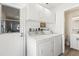 Convenient laundry room with washer, dryer, storage cabinets, and adjacent bathroom at 1489 Dundee Dr, Palm Harbor, FL 34684