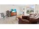 Bright living room featuring wood flooring, a front view window, and comfortable seating at 1489 Dundee Dr, Palm Harbor, FL 34684