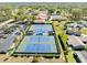 Aerial view of well-maintained tennis courts, surrounded by lush greenery and residential buildings at 1489 Dundee Dr, Palm Harbor, FL 34684