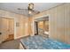 Comfortable bedroom with wood paneled walls and a ceiling fan at 15 Shore Dr, Palm Harbor, FL 34683