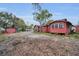 Exterior view of a single-Gathering home with a gravel driveway and mature trees at 15 Shore Dr, Palm Harbor, FL 34683