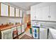 Kitchen features wood countertops, white cabinets, and vintage stool seating at 15 Shore Dr, Palm Harbor, FL 34683