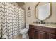 Bathroom vanity has granite countertops, dark wood cabinets and a patterned shower curtain at 16312 Palmettoglen Ct, Lithia, FL 33547