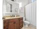 Bathroom featuring granite counters, dark wood cabinets and a shower/bath with curtain at 16312 Palmettoglen Ct, Lithia, FL 33547