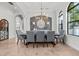 Formal dining room features travertine floors, contemporary chandelier, and gray accent wall at 16312 Palmettoglen Ct, Lithia, FL 33547