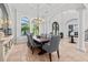 Large formal dining room area with high ceilings, travertine flooring, a decorative chandelier and gray color palette at 16312 Palmettoglen Ct, Lithia, FL 33547