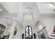 Grand foyer with high ceilings, arched doorways, and elegant staircase with beautiful chandeliers above at 16312 Palmettoglen Ct, Lithia, FL 33547
