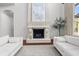 Cozy living room displaying fireplace, hardwood floors, neutral furniture, and large windows with light at 16312 Palmettoglen Ct, Lithia, FL 33547