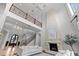 Gorgeous living room featuring hardwood floors, a stone fireplace, wrought-iron staircase, and light-filled windows at 16312 Palmettoglen Ct, Lithia, FL 33547