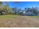 Expansive backyard with mature trees and a large outbuilding at 16349 Spring Valley Rd, Dade City, FL 33523
