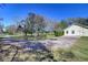 Exterior view of home with a sprawling yard, mature trees, and a gravel driveway at 16349 Spring Valley Rd, Dade City, FL 33523