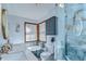 Bright bathroom featuring a double sink vanity, blue marble-style tile and glass-enclosed shower at 16349 Spring Valley Rd, Dade City, FL 33523
