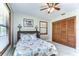 Bright bedroom features white marble floors, coastal-themed bedding, a ceiling fan, and a spacious closet at 16349 Spring Valley Rd, Dade City, FL 33523