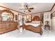 Elegant bedroom with a four-poster bed, marble floors, ceiling fan and lots of mirrors at 16349 Spring Valley Rd, Dade City, FL 33523