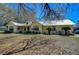 Charming yellow single-story home with a metal roof, well-maintained landscaping, and inviting front porch at 16349 Spring Valley Rd, Dade City, FL 33523