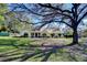 A charming single-story home with a well-manicured lawn and mature trees providing shade and curb appeal at 16349 Spring Valley Rd, Dade City, FL 33523
