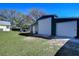 A large detached garage with two roll-up doors and ample parking space, set in a well-maintained backyard at 16349 Spring Valley Rd, Dade City, FL 33523