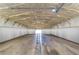 Large, unfinished warehouse or garage interior featuring an open ceiling and concrete floor at 16349 Spring Valley Rd, Dade City, FL 33523