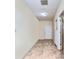 An empty hallway with tile floor, neutral paint and doors at 16349 Spring Valley Rd, Dade City, FL 33523