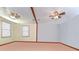 Spacious, bright living room features neutral walls, two windows, two ceiling fans, and wood trim at 16349 Spring Valley Rd, Dade City, FL 33523