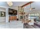 Bright living room with stone fireplace, TV, and view of screened in pool area at 16349 Spring Valley Rd, Dade City, FL 33523