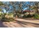 Gated community entrance featuring well manicured landscaping, mature oak trees, and brick paver streets at 1712 Hammock Pine Blvd # 1712, Clearwater, FL 33761