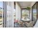 Enclosed sunroom with white wicker furniture, bright light, and a serene view, perfect for relaxing or entertaining at 1712 Hammock Pine Blvd # 1712, Clearwater, FL 33761
