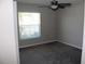 A cozy bedroom featuring gray walls, a ceiling fan, carpeted floor, and a window for natural light at 17152 Sunshine Mimosa St, Wimauma, FL 33598