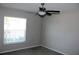 A cozy bedroom featuring gray walls, a ceiling fan, carpeted floor, and a window for natural light at 17152 Sunshine Mimosa St, Wimauma, FL 33598