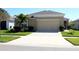 Charming single-story home featuring well-maintained landscaping and an attached two-car garage with a wide concrete driveway at 17152 Sunshine Mimosa St, Wimauma, FL 33598