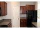 Well-equipped kitchen features stainless steel appliances, dark wood cabinets, and granite countertops at 17152 Sunshine Mimosa St, Wimauma, FL 33598