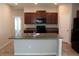Kitchen features an island, sleek black appliances, dark wood cabinetry, and granite countertops at 17152 Sunshine Mimosa St, Wimauma, FL 33598