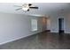 Bright living room featuring neutral walls, tiled floor, and a ceiling fan with light at 17152 Sunshine Mimosa St, Wimauma, FL 33598