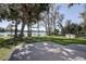 Backyard with patio area, large trees, and a waterfront view at 18715 Lakeshore Dr, Lutz, FL 33549