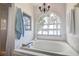 Serene bathroom featuring a soaking tub, arched window with a view, and soft lighting at 18715 Lakeshore Dr, Lutz, FL 33549