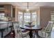 Bright breakfast nook with bay windows overlooking the lake and circular wood table with chairs at 18715 Lakeshore Dr, Lutz, FL 33549