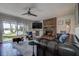 Comfortable living room with brick fireplace, ceiling fan, leather sofa, and sliding door to the backyard at 18715 Lakeshore Dr, Lutz, FL 33549