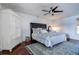 Stylish main bedroom with ceiling fan, white wardrobe and bed with blue and white patterned bedding at 18715 Lakeshore Dr, Lutz, FL 33549