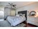 Bright main bedroom with wooden floors, a ceiling fan, and a comfortable bed topped with patterned bedding at 18715 Lakeshore Dr, Lutz, FL 33549