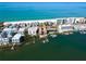 Gorgeous aerial view of waterfront condos, boat docks, and a white sandy beach, offering the ultimate coastal lifestyle at 19937 Gulf Blvd # B-3, Indian Shores, FL 33785